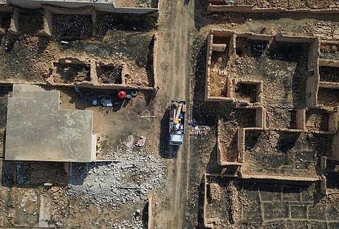 A truck carrying returning residents and their belongings passes destroyed buildings in Al-Arisha, in Syria's Ras al-Ayn countryside, Tuesday, Oct. 13, 2026, seven years after a Turkish military offensive alongside allied Syrian factions forced them to flee. 