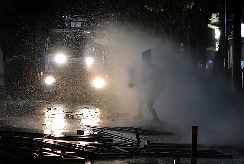 A police water cannon sprays water at a protester during clashes in Tirana, Albania, Tuesday, Oct. 13, 2026, joining a demonstration organized by the Flamingo protest movement demanding the resignation of Prime Minister Edi Rama. 