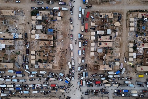 Trucks packed with belongings line the roads at al-Talayi camp as displaced families get ready to return to the Ras al-Ayn countryside, in Hassakeh, Syria, Tuesday, Oct. 13, 2026. 