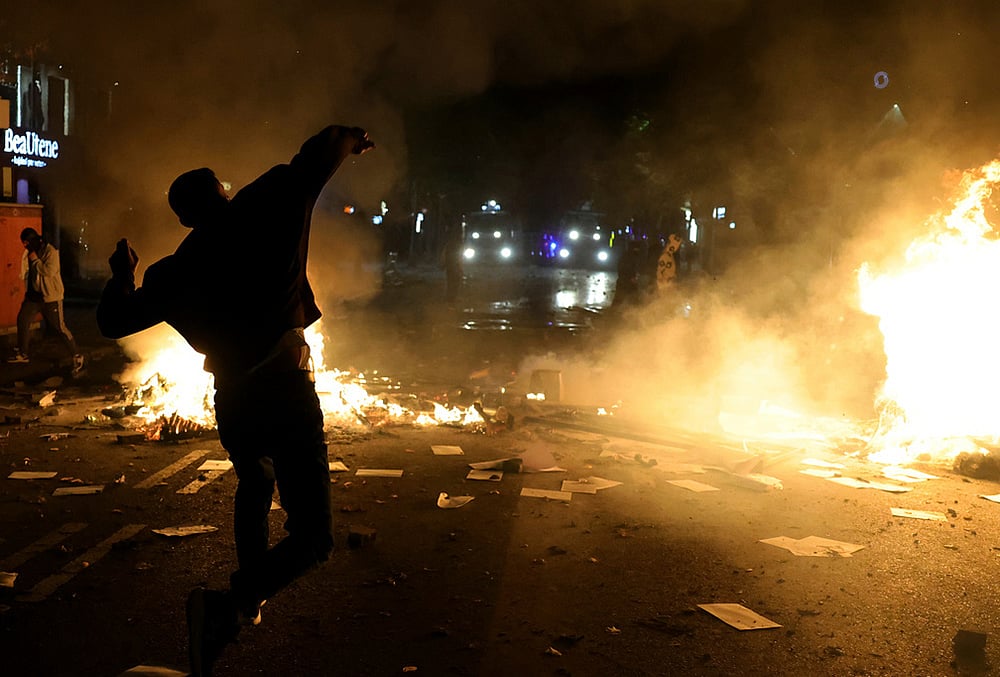 A protester throws a stone at police during clashes in Tirana, Albania, Tuesday, Oct. 13, 2026, joining a demonstration organized by the Flamingo protest movement demanding the resignation of Prime Minister Edi Rama.  - | Photo: AP/Hameraldi Agolli