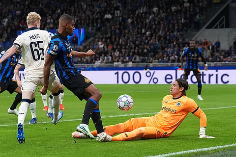 Inter Milan's Andy Diouf , left, attempts a goal as Brugge's goalkeeper Yann Sommer saves during the Champions League opening phase soccer match between Inter Milan and Club Brugge in Milan, Italy, Tuesday, Oct. 13, 2026.