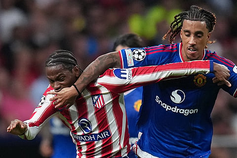 Manchester United's Leny Yoro, right, fouls Atletico Madrid's Jonathan David during the Champions League opening phase soccer match between Atletico Madrid and Manchester United in Madrid, Tuesday, Oct. 13, 2026.