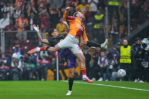 Galatasaray's Baris Yilmaz, top, fights for the ball with Barcelona's Joao Cancelo during the Champions League opening phase soccer match between Galatasaray and Barcelona in Istanbul, Turkey, Tuesday, Oct. 13, 2026.