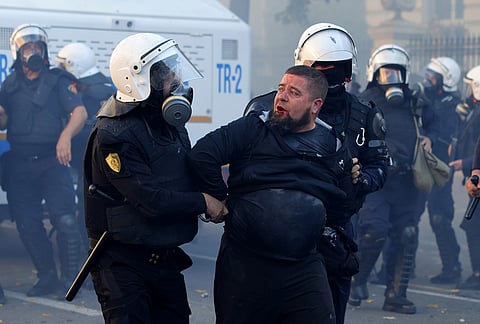Riot police detain a protester during clashes near the Ministry of Education in Tirana, Albania, Tuesday, Oct. 13, 2026, joining a demonstration organized by the Flamingo protest movement demanding the resignation of Prime Minister Edi Rama. 
