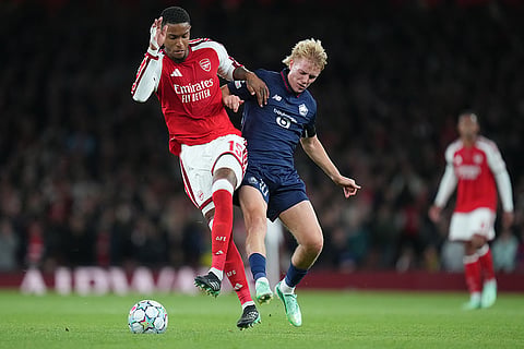 Arsenal's Ezri Konsa, left, and Lille's Hakon Haraldsson fight for the ball during the UEFA Champions League soccer match between Arsenal and Lille in London, Tuesday, Oct. 13, 2026.