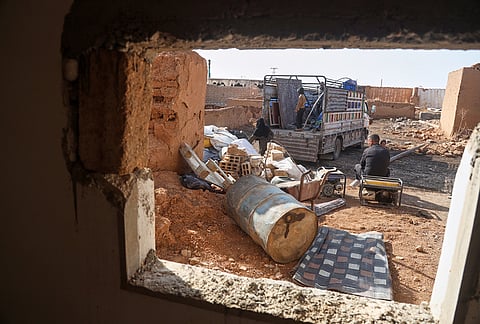 Returning residents unload belongings from a truck amid damaged buildings in Al-Arisha, in Syria's Ras al-Ayn countryside, Tuesday, Oct. 13, 2026, seven years after a Turkish military offensive backed by allied Syrian factions forced them to flee. 
