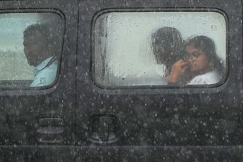 Commuters travel in a car during heavy rainfall, in New Delhi, Thursday, Oct. 15, 2026.