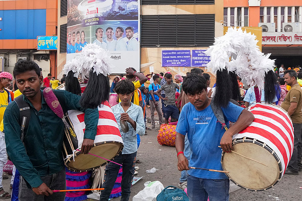 Dhakis, traditional Bengali drummers, display their skills as they arrive at Sealdah railway station from rural areas, hoping to be hired by Durga Puja committees for the remaining four days of the festival, in Kolkata, West Bengal, Thursday, Oct. 15, 2026. - | Photo: PTI/Swapan Mahapatra