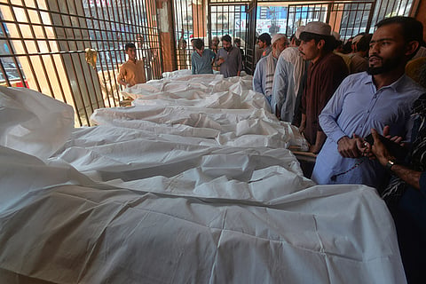 Parents gather at a hospital next to the bodies of children, who died in the roof collapse of a private school, in Peshawar, Pakistan, Thursday, Oct. 15, 2026.
