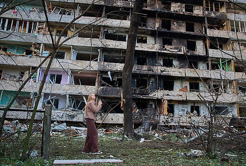 A young woman reacts as she looks at her damaged home after Russia's night missile attack in Kyiv, Ukraine, Wednesday, Oct. 14, 2026. 