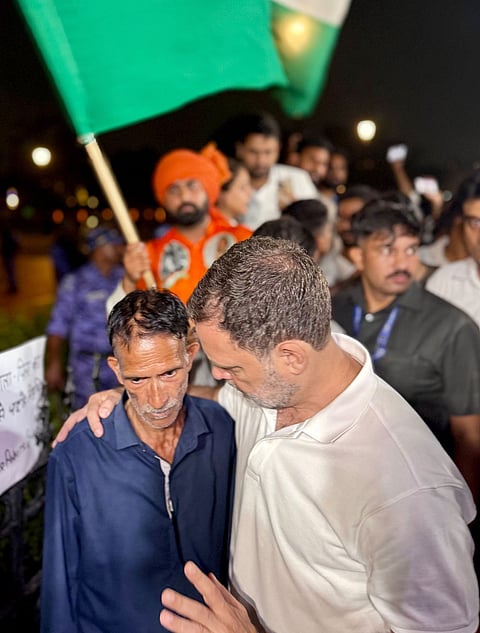 In this image posted on Oct. 14, 2026, Lok Sabha Leader of Opposition (LoP) Rahul Gandhi interacts with father of Ankita Bhandari during a sit-in protest at India Gate, in New Delhi. LoP Rahul Gandhi and Priyanka Gandhi joined the family to express solidarity with their demand to put on hold the gubernatorial appointment of a BJP leader whose name they allege is linked to the case.