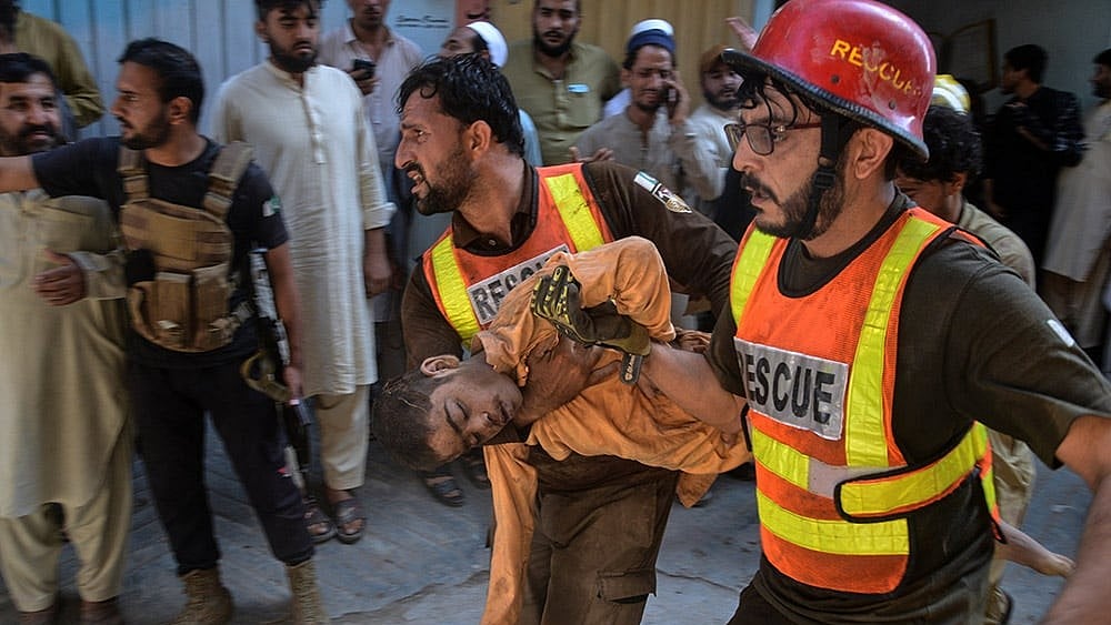 Rescue workers carry an injured boy after rescuing him from the rubble of a roof collapse at a private school, in Peshawar, Pakistan, Thursday, Oct. 15, 2026. - | Photo: AP/Muhammad Zubair