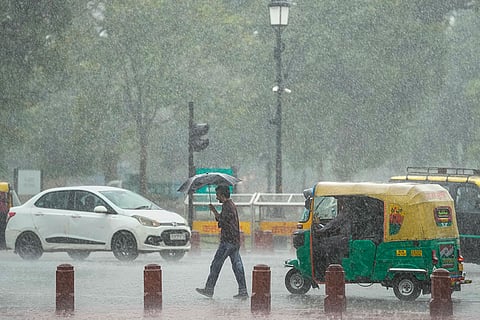 Commuters move amid heavy rainfall, in New Delhi, Thursday, Oct. 15, 2026.