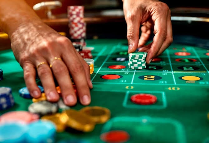 Hands placing betting chips on a roulette table