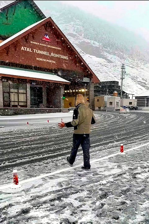 A person walks through fresh snowfall near the North Portal of the Atal Tunnel, in Lahaul-Spiti district, Himachal Pradesh, Thursday, Oct. 15, 2026. 
