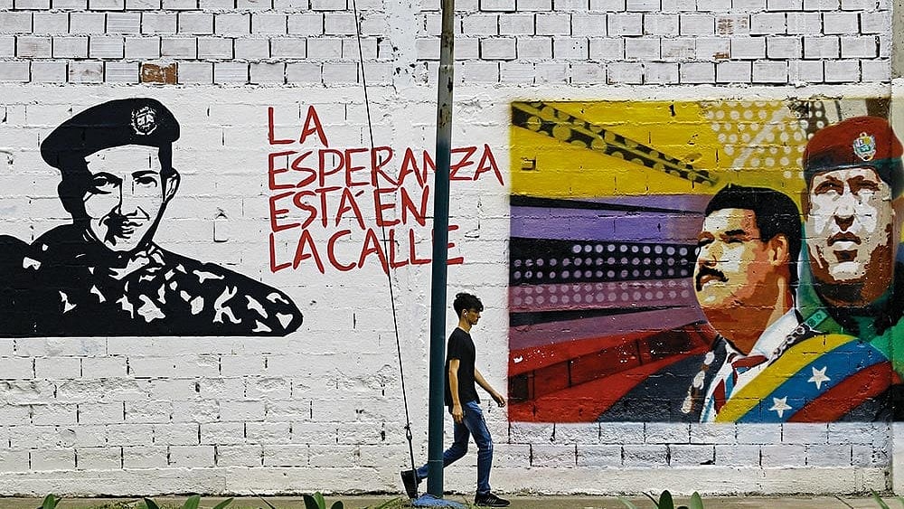 Leaders on the Wall: A man walks past grafitti in Valencia city, Venezuela, depicting Nicolás Maduro, Simón Bolivar and Hugo Chávez  - | Photo: Imago/Zuma Press Wire
