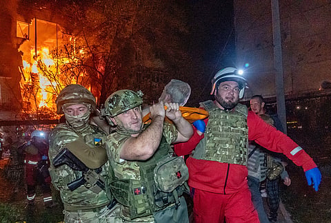 Rescuers evacuate an injured civilian after a residential building was hit following a Russian air attack in Kharkiv, Ukraine, Tuesday, Oct. 13, 2026. 
