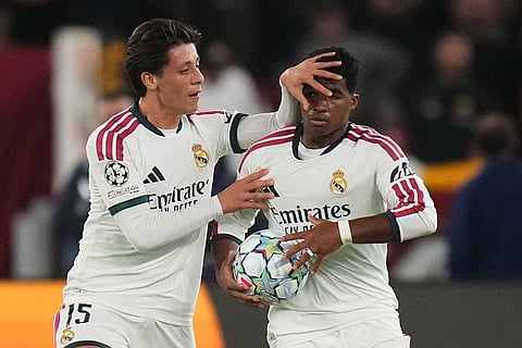 Real Madrid's Endrick celebrates with his teammate Arda Guler after scoring his side's third gola during a Champions League opening phase soccer match between Roma and Real Madrid, in Rome, Wednesday, Oct.14, 2026.