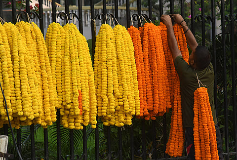 A vendor arranges marigold garlands for sale during the Durga Puja festival, in Guwahati.