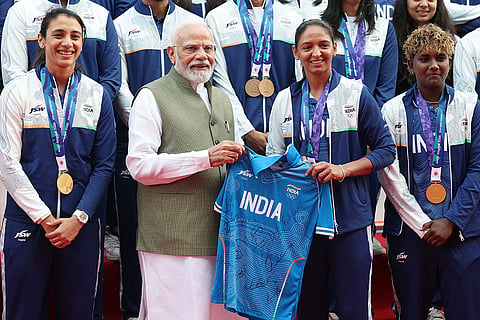In this image posted on Oct. 15, 2026, Prime Minister Narendra Modi is presented a jersey by Indian women's cricket team captain Harmanpreet Kaur during an interaction programme with the athletes of the Asian Games 2026, in New Delhi.