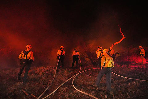 Crews make a stand in front of the Bryson Fire on Thursday, Oct. 15, 2026, in Malibu, California. 

