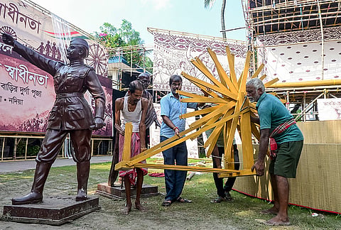 Artisans install a 'Charkha' at a Durga Puja pandal themed on India's independence movement, in Nadia, West Bengal, Monday, Oct. 12, 2026. 