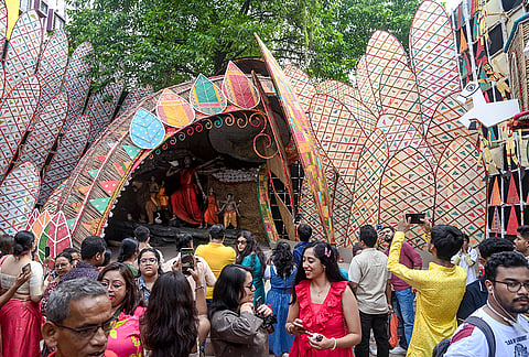 People at a community pandal themed on various Bengali celebrations throughout the year on 'Maha Sasthi' during the Durga Puja festival, in Kolkata, West Bengal, Friday, Oct. 16, 2026. 
