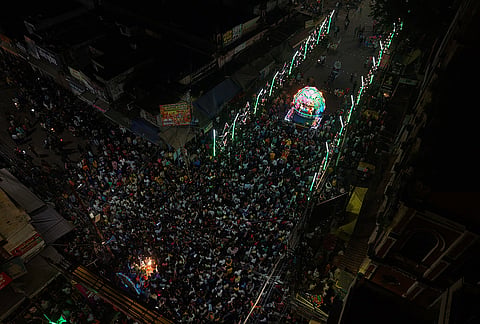 People gather during the 'Bhor Ki Shringar Chowki', a religious procession featuring artists dressed as lord Rama, Lakshmana and goddess Sita, ahead of Dussehra festival, in Prayagraj.