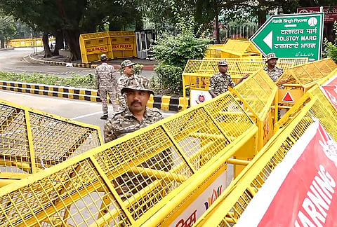 Police personnel stand near barricades ahead of a Tiranga March rally by Cockroach Janata Party (CJP), at Tolstoy Marg, in New Delhi, Friday, Oct. 16, 2026.