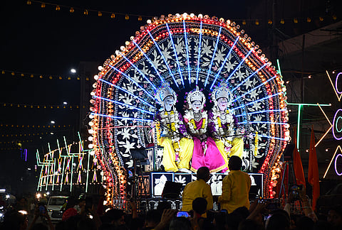 People gather during the 'Bhor Ki Shringar Chowki', a religious procession featuring artists dressed as lord Rama, Lakshmana and goddess Sita, ahead of Dussehra festival, in Prayagraj.