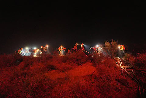 Fire crews line up while battling the Bryson Fire on Thursday, Oct. 15, 2026, in Malibu, California. 
