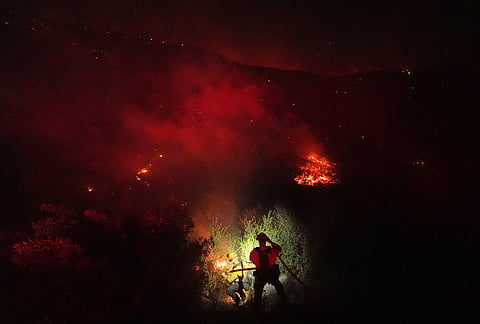 Crews make a stand in front of the Bryson Fire on Thursday, Oct. 15, 2026, in Malibu, California. 

