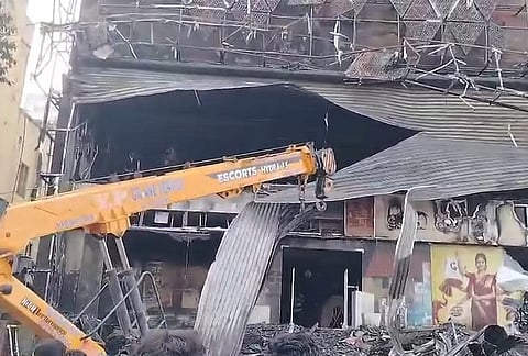 A crane removes damaged structure after a fire broke out at GV Mall, in Kurnool, Andhra Pradesh.