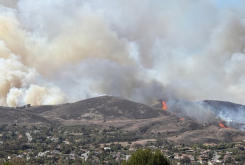 This photo provided by Cameron Cosgrove shows smoke billowing up from the Norte fire in San Clemente, California Friday, Oct. 16, 2026. 