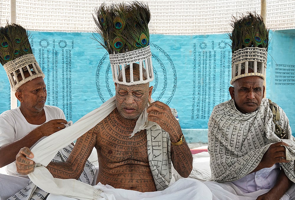 Members of the Ramnami community, a Hindu devotional sect from Chhattisgarh, are seen at a community puja pandal during the ongoing 'Durga Puja' festival, in Kolkata, West Bengal, Saturday, Oct. 17, 2026. The community members tattoo the sacred name 'Ram' on their skin, transforming their bodies into living temples, as an act of rebellion against discrimination by the higher castes. 
 - | Photo: PTI/Swapan Mahapatra