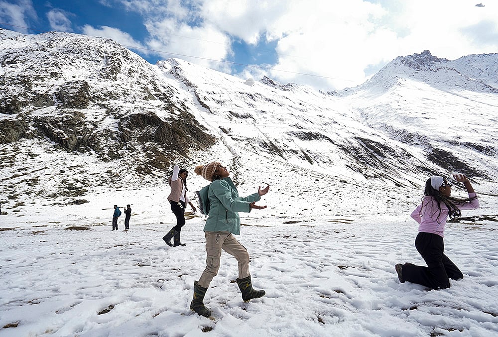Tourists play with snow at Zero Point Zojila on the Srinagar-Leh National Highway, in Jammu and Kashmir, Saturday, Oct. 17, 2026.  - | Photo: PTI/Burhaan Kinu