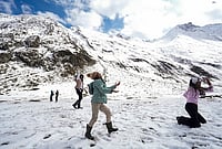 Fresh Snowfall At Zojila Pass In Photos: Tourists Enjoy Snow, Army Keeps Vigil | Photo: PTI/Burhaan Kinu : Tourists play with snow at Zero Point Zojila on the Srinagar-Leh National Highway, in Jammu and Kashmir, Saturday, Oct. 17, 2026.