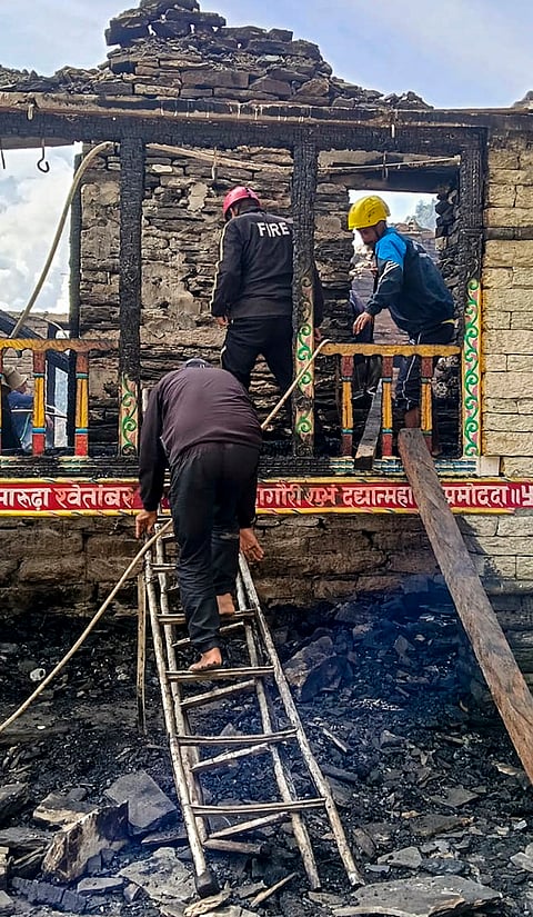 Firemen inspect the area after a fire broke out at the Ma Bhagwati temple, an ancient wooden temple dedicated to Goddess Bhagwati, at Badiyakot area in Bageshwar district, Uttarakhand, Friday, Oct. 16, 2026. 
