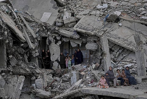 Palestinian women and children watch the Palestine Strongman Championship from among the rubble of destroyed buildings in Gaza City.