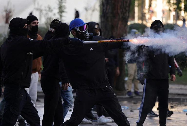 A hooded protester uses fireworks against riot police during an anti-government demonstration in Tirana, Albania, Friday, Oct. 16, 2026.
- | Photo: AP/Hameraldi Agolli