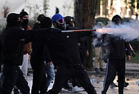 | Photo: AP/Hameraldi Agolli : A hooded protester uses fireworks against riot police during an anti-government demonstration in Tirana, Albania, Friday, Oct. 16, 2026. 
