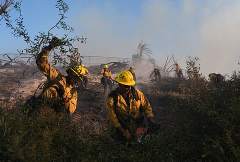 Crews clear brush while fighting the Norte Fire on Friday, Oct. 16, 2026, in San Juan Capistrano, California.
