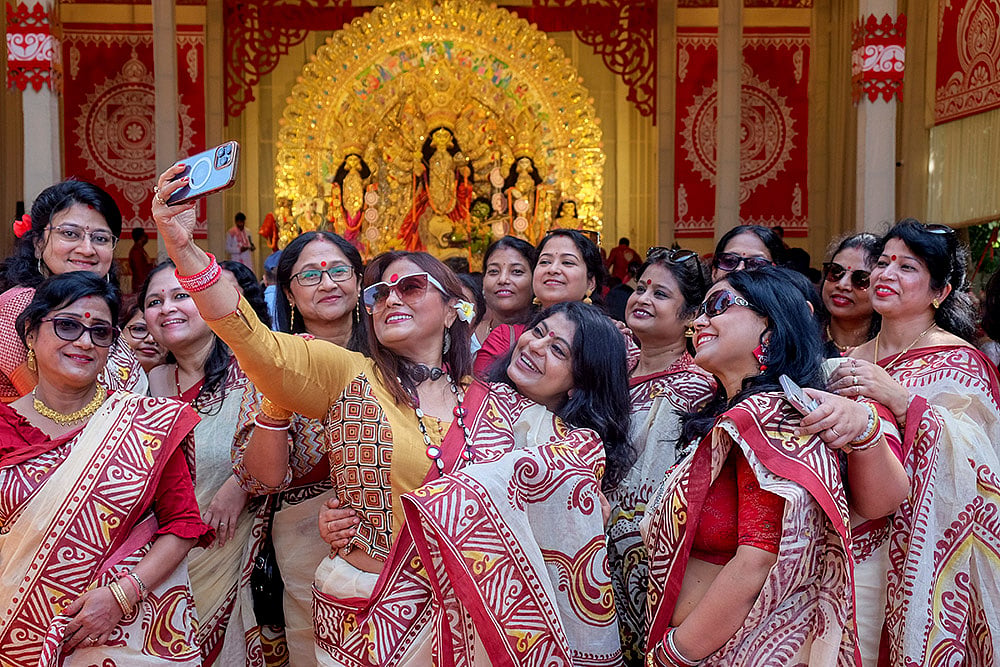 Women take selfies at a pandal during Durga Puja festival, in Gurugram, Sunday, Oct. 18, 2026. - | Photo: PTI 