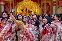 Day In Pics: October 18, 2026 | Photo: PTI : Women take selfies at a pandal during Durga Puja festival, in Gurugram, Sunday, Oct. 18, 2026.