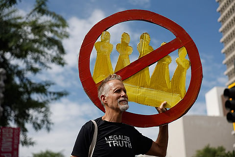 A demonstrator holds a "No Kings" sign during a protest in Los Angeles on Saturday, Oct. 17, 2026.