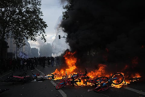 Bicycles burn during a demonstration against rising living costs, joining students' grievances, in Paris, Saturday, Oct. 17, 2026.