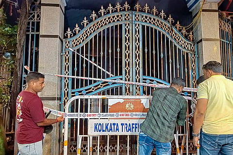 Police personnel put up cordon tape to seal the entry gate of the Chorbagan Sarbojanin Durga Puja pandal following a stampede-like situation caused by an exit gate collapse due to heavy crowd pressure, in Kolkata, Saturday, Oct. 17, 2026.