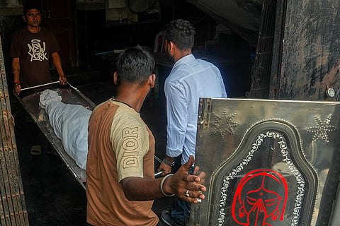 People carry the mortal remains of a victim killed in a stampede at the Chorbagan Durga Puja pandal, at a mortuary in Kolkata, Sunday, Oct. 18, 2026. At least 19 people were killed and 25 others injured in the incident.