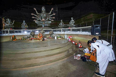 Kolkata Police personnel examine scattered belongings inside a Durga Puja pandal after a stampede-like situation triggered by an exit gate collapse due to heavy crowd pressure, in Kolkata, Saturday, Oct. 17, 2026. 