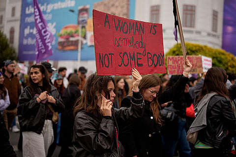 A woman holds a placard during a protest aiming to raise awareness to the violence and prejudice against womean in Romanian society, in Bucharest, Romania, Saturday, Oct. 17, 2026.
